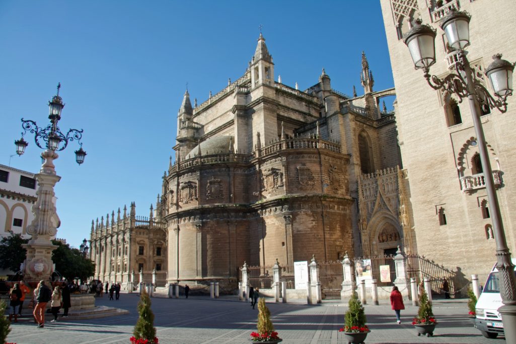 Vue de la cathédrale de Séville, avec des bâtiments historiques et un ciel bleu dégagé.