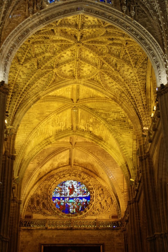 Plafond en voûte ornée et rosace colorée d'une cathédrale.