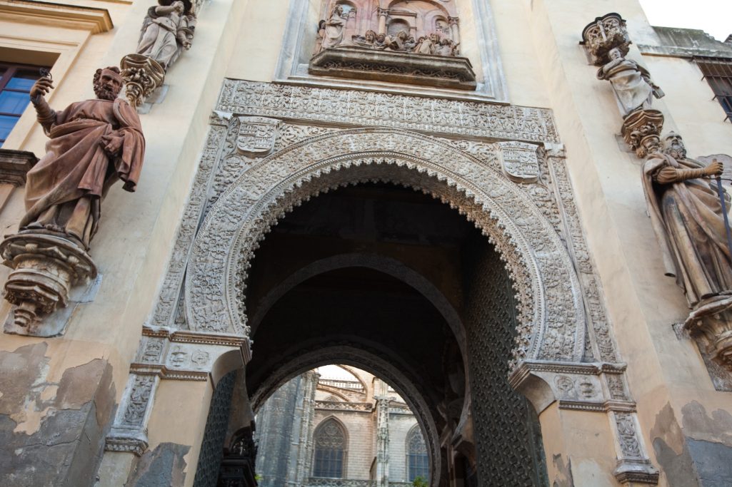 Arcade décoré avec statues sculptées et détails architecturaux richement ornés.