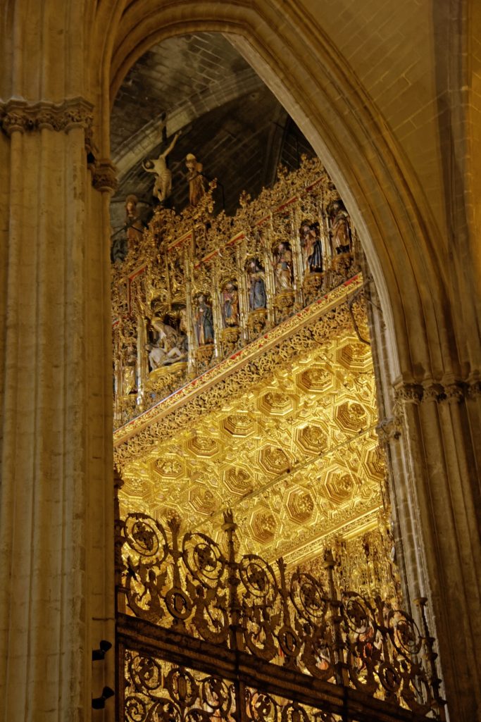 Détails architecturaux d'une cathédrale avec une voûte ornée et un balcon doré.